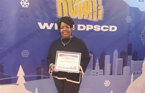  principal posing with award